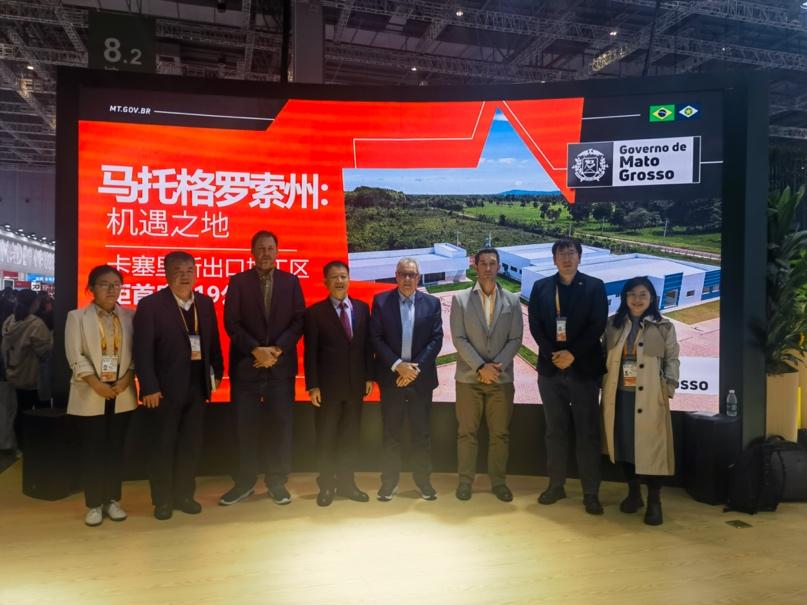 A group of men standing in front of a large screenDescription automatically generated